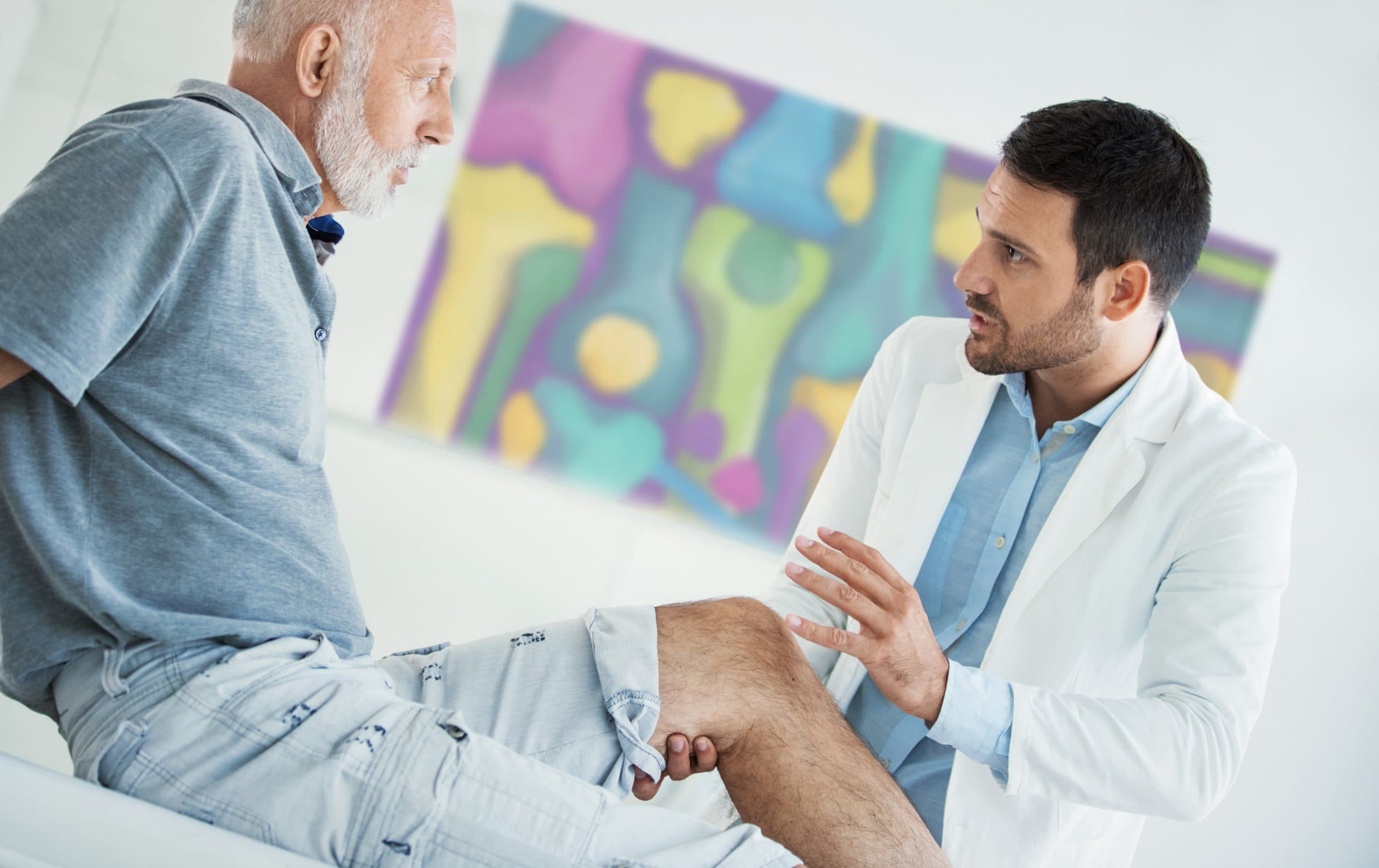 Doctor discussing knee symptoms with elderly patient